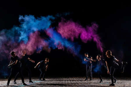 A group of six young friends of boys and girls throw holi paints at eachの写真素材