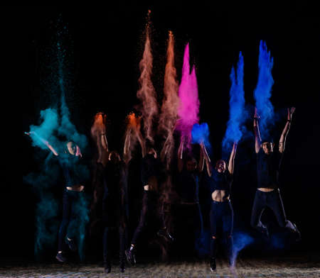 A group of six young friends of boys and girls throw holi paints at eachの写真素材