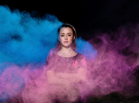 Young beautiful caucasian girl stands covered with holi paintsの写真素材