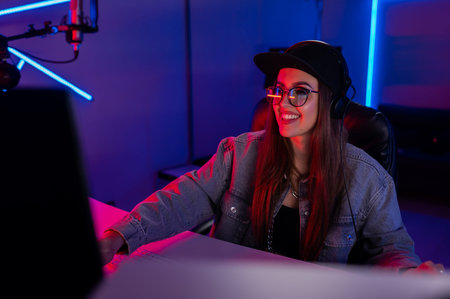 Beautiful caucasian girl in stylish clothes works in a recording studio