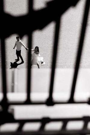 Beautiful young caucasian bride in white goes holding the hand of the groom