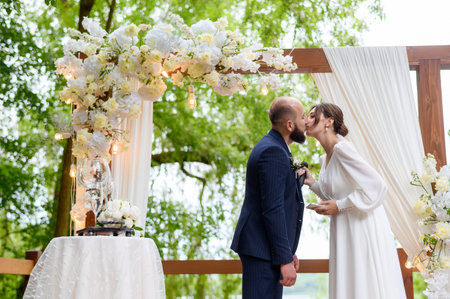 A young beautiful couple of newlyweds pose against the background of the arch