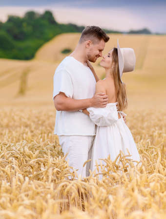 Beautiful young Caucasian couple in white clothes posing and huggingの写真素材
