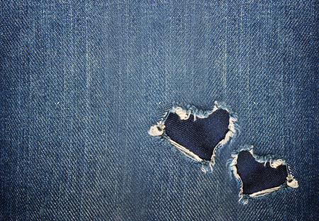 heart shape torn from blue denim jeans fabric with copy space in romantic love concept backgroundの写真素材