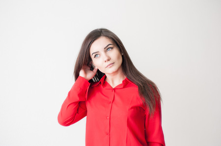 Portrait of a young girl on a white background in a red shirtの写真素材