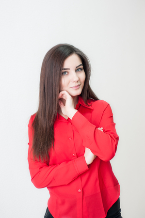 Portrait of a young girl on a white background in a red shirtの写真素材