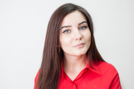 Portrait of a young girl on a white background in a red shirtの写真素材