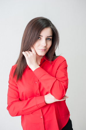 Portrait of a young girl on a white background in a red shirtの写真素材