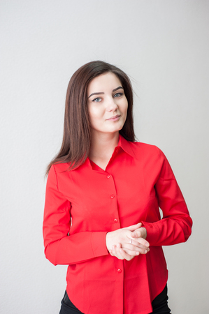 Portrait of a young girl on a white background in a red shirtの写真素材