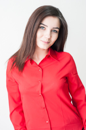Portrait of a young girl on a white background in a red shirtの写真素材