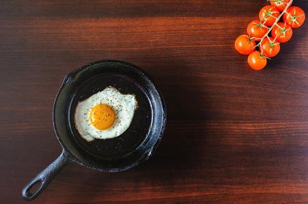 fried eggs mozzarella with basil and tomatoes on a frying panの写真素材