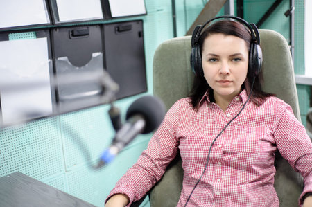 A radio DJ announces news in a radio-studio