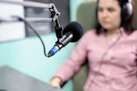 A radio DJ announces news in a radio-studioの写真素材