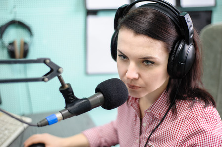 A radio DJ announces news in a radio-studioの写真素材