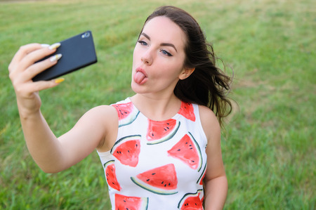 Young beautiful girl doing selfie at sunsetの写真素材