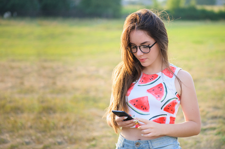 Portrait of a young woman in a park at sunsetの写真素材