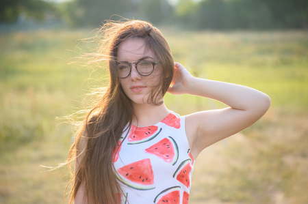 Portrait of a young woman in a park at sunsetの写真素材
