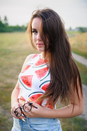 Portrait of a young woman in a park at sunsetの写真素材