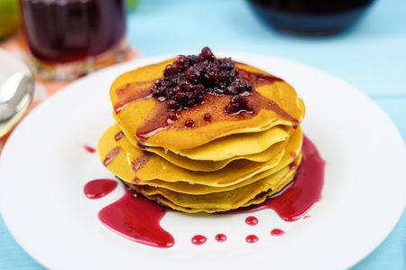 Pancakes with raspberry jam and grape juice on a blue backgroundの写真素材