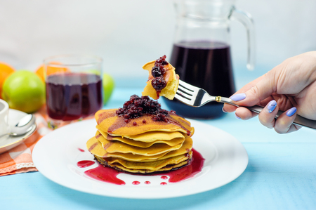 Pancakes with raspberry jam and grape juice on a blue backgroundの写真素材