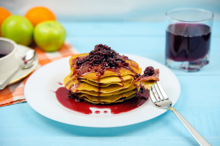 Pancakes with raspberry jam and grape juice on a blue backgroundの写真素材