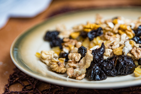 Mixed dried fruit on plate, nuts, plums, fruitcake igedientsの写真素材