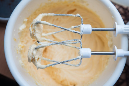 Two electric mixer beaters after beating eggs for cake
