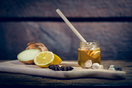 Natural medicones against flue and cold. Honey, lemon, hot tea, onion and garlic. Health concept.の写真素材
