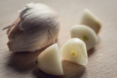 Close-up view at sliced garlic cloves and whole clovesの写真素材