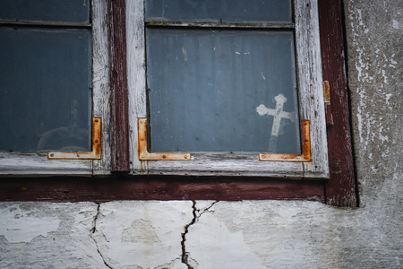 Christian cross in the window of the old houseの写真素材
