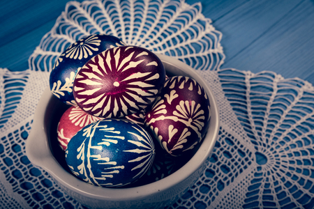 Group of hand painted easter eggs on the blue wooden surfaceの写真素材