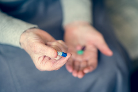 Senior woman holding five tablets in her hands. Senility conceptの写真素材