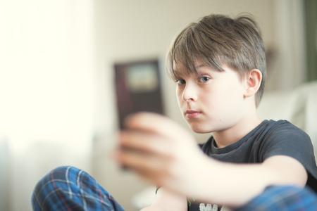 A boy doing selfie with his smartphoneの写真素材