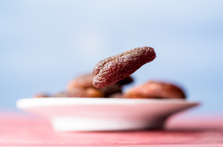 One flying dried apricot. More apricots in backgroundの写真素材