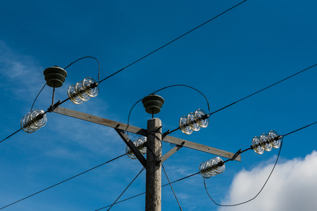 Wooden electric pole with blue sky in backgroundの写真素材