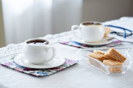 Two white oldfashioned cup of tea or caffee on the table at home. Stay at home concept.の写真素材