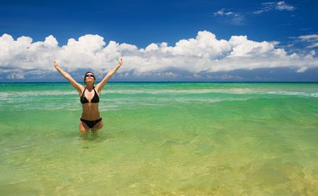 A beautiful woman wearing a bikini on a vacant beach in paradiseの写真素材