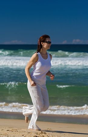 Woman running on the beach in tropicsの写真素材