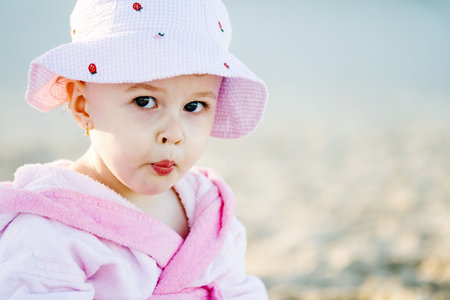  girl in pink sitting on the beachの写真素材