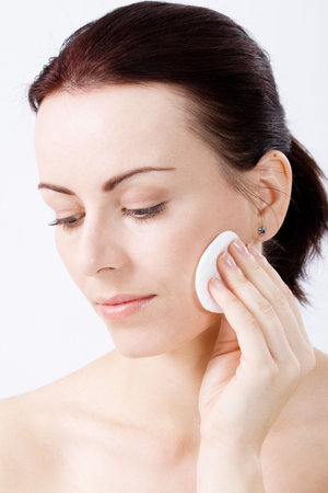 Natural beauty applying make up to her cheek