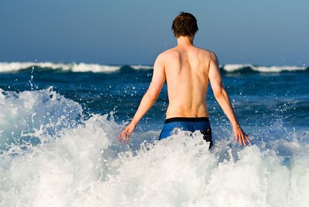 Man facing the waves of the oceanの写真素材