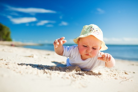 Little toddler on the beach exploring the sandの写真素材