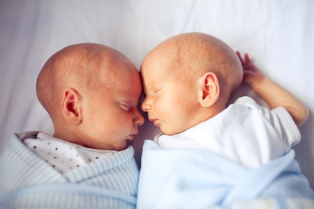 Newborn twins sleeping and bonding togetherの写真素材