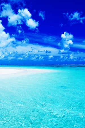 Empty beach with blue sky and vibrant ocean colorsの写真素材