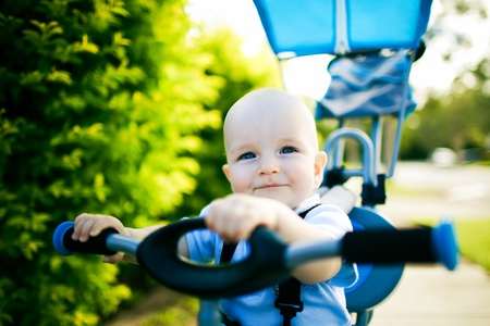 Close up of a happy child sitting on bicycle outdoorsの写真素材