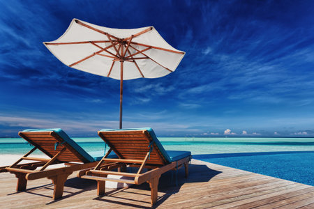 Deck chairs and infinity pool over amazing tropical lagoonのeditorial素材