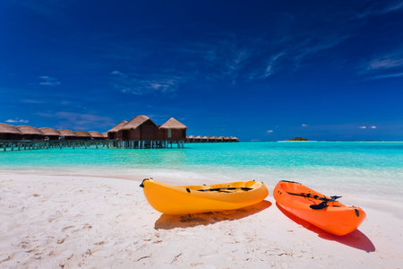 Two colourful kayaks on the tropical beach