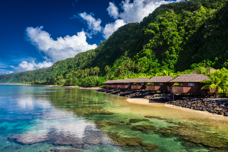 Tropical beach with with coconut palm trees and beach houses on Samoa, Upolu Islandの写真素材