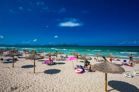 PLAYA DE MURO, Mallorca, Spain - 23 July 2020 - People enjoying hot summer day on popular sandy city beach in Mallorca.のeditorial素材