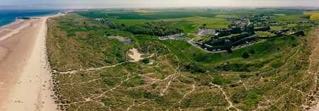 UK, England, Northumberland, Bamburgh Castle on hill near beachの写真素材